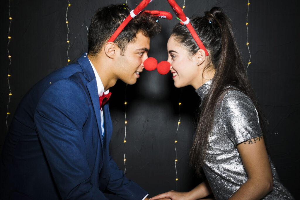 young couple with red deer antlers headbands funny noses